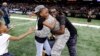 FILE - Family members rush to greet Air Force Technical Sergeant Anthony Williams, who was based in Qatar, during a surprise reunion at halftime of a National Football League game in New Orleans, Dec. 24, 2016. Most people would characterize "blood is thicker than water" as a way of saying family relationships are the most important ones. But the phrase has very different origins.