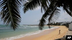 In this Friday, May 10, 2019, photo, a boy walks on a beach in Hikkaduwa, Sri Lanka. (AP Photo/Eranga Jayawardena)