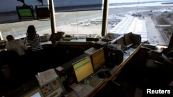 Reagan National Airport air traffic controller Sundie Yukich (2nd L) directs aircraft from the control tower in Washington, Feb. 28, 2013. 