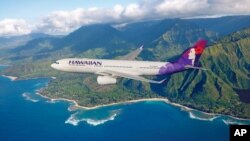 FILE - A Hawaiian Airlines plane flies above Hawaii.