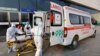 不断变种的新冠毒株，为2022北京冬奥会蒙上极大的不确定阴影。图为身穿防护服的红十字会救护人员在北京的一个媒体中心将一个担架送入救护车中。（路透社2022年1月7日）