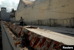 An officer walks at a collapsed prison following an earthquake in Palu, Central Sulawesi, Indonesia, Oct. 2, 2018.