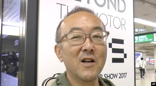 Yoh Kawakami, employee at an information management solution company, is interviewed by the Associated Press, Oct. 22, 2017, about President Donald Trump's visit to Asia in Tokyo, Japan.