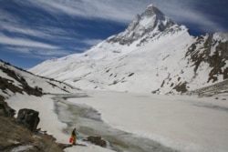 A Hindu holy man, gets water from a stream at the foot of Mount Shivling in Tapovan. Tapovan is located just above Gangotri glacier, which is one of the primary sources of water for the Ganges. May 10, 2019.