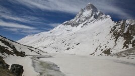 A Hindu holy man, gets water from a stream at the foot of Mount Shivling in Tapovan. Tapovan is located just above Gangotri glacier, which is one of the primary sources of water for the Ganges. May 10, 2019.