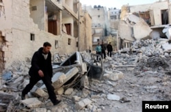 Men inspect a site hit by what activists said was an airstrike by forces loyal to President Bashar al-Assad in the al-Sukkari neighborhood in Aleppo, Feb. 4, 2014.