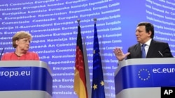 German Chancellor Angela Merkel, left, looks at European Commission President Jose-Manuel Barroso as he speaks during a news conference at the European Commission headquarters in Brussels, Oct. 5, 2011.