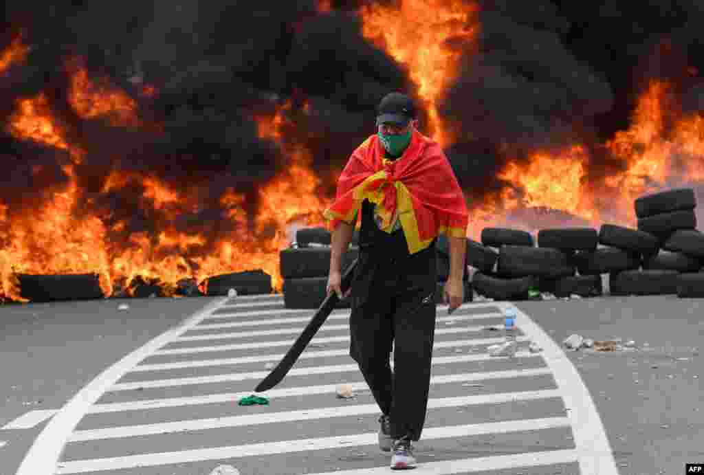 A man walks past burning tires at a barricade set up to block access roads to the historic city of Cetinje during a protest against the inauguration of the new head of the Serbian Orthodox Church in Montenegro.
