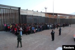 U.S. Border Patrol agents keep watch on a large group of migrants who they say were attempting to cross the U.S.-Mexico border illegally, in El Paso, Texas, May 29, 2019.