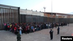 U.S. Border Patrol agents keep watch on a large group of migrants who they say were attempting to cross the U.S.-Mexico border illegally, in El Paso, Texas, May 29, 2019.