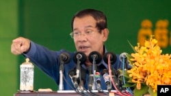 Cambodia's Prime Minister Hun Sen speaks to garment workers during a visit to a factory outside Phnom Penh, Cambodia, Wednesday, Aug. 30, 2017. Hun Sen is on a country-wide trip visiting the nation's factory workers to hear their hopes and concerns in person. (AP Photo/Heng Sinith)