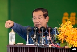 FILE-Cambodia's Prime Minister Hun Sen speaks to garment workers during a visit to a factory outside Phnom Penh, Cambodia, Wednesday, Aug. 30, 2017.