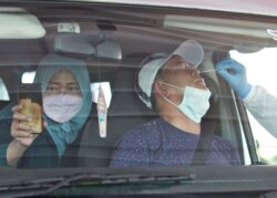 Para pengemudi dan penumpang wajib test swab COVID-19 saat kembali ke ibu kota setelah mudik lebaran di tengah pandemi COVID-19, di Cikarang, Bekasi, di pinggiran kota Jakarta, 17 Mei 2021.