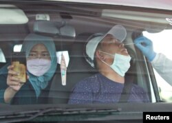 Para pengemudi dan penumpang wajib test swab COVID-19 saat kembali ke ibu kota setelah mudik lebaran di tengah pandemi COVID-19, di Cikarang, Bekasi, di pinggiran kota Jakarta, 17 Mei 2021.