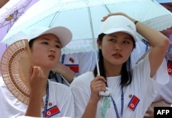 In this 2003 photo, North Korean cheerleaders watch their team play Germany in the women's football match in Gimcheon Stadium.