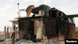 A man inspects damage at an oil refinery and a gas station that were targeted by what activists said were U.S.-led air strikes, in the town of Tel Abyad of Raqqa governorate, near the border with Turkey, Oct. 2, 2014.