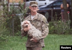 ارما سے متاثرہ شہر آرلینڈو میں ایک فوجی ، ایک مکان میں بھنسے ہوئے بالتو کتے کو نکال کر لا رہا ہے