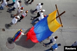 Demonstrators hold a cross as they take part in a rally to honor victims of violence during a protest against Venezuelan President Nicolas Maduro's government in Caracas, Venezuela, April 22, 2017.