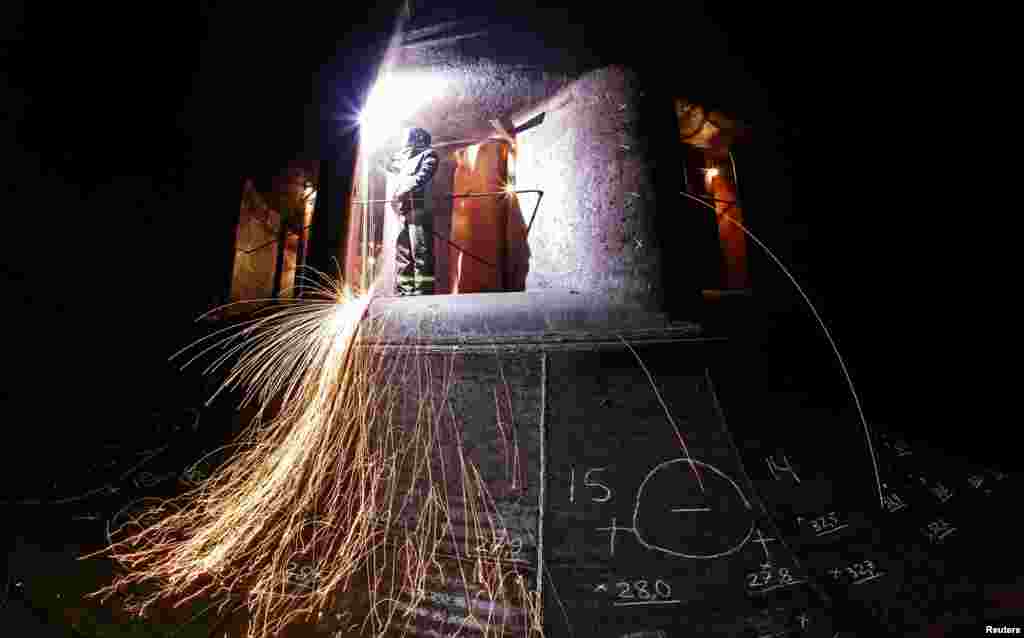 A welder works inside the 7th hydro unit of the Krasnoyarsk hydroelectric power station, located on the Yenisei River outside Krasnoyarsk, Russia.