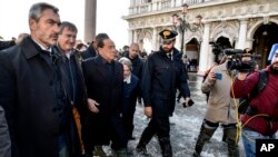 El ex primer ministro italiano Silvio Berlusconi, 3ro desde la izquierda, acompañado del alcalde de Venecia Luigi Brugnaro, izquierda, y otros funcionarios caminan en medio del agua en la Plaza de San Marcos en Venecia. nov.14, 2019. AP/Luigi Constantini.