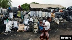 FILE - Children walk past charcoal sellers in Kitwe, Zambia, Jan. 17, 2015. With drought harming crop yields across southern Africa, officials say food insecurity and the struggling economy are pushing more people to cut down trees to produce charcoal for sale.