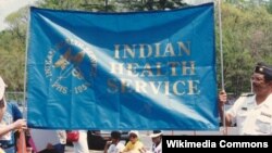 FILE - In this 1992 photo, unidentified Native Americans hold up an Indian Health Service banner.