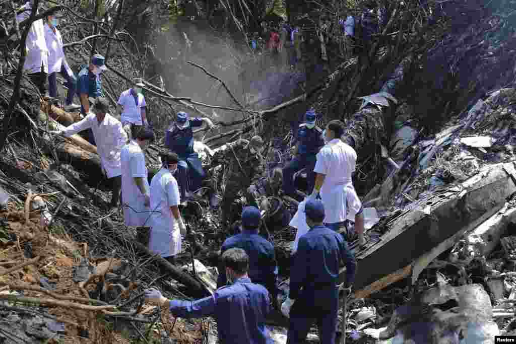 Rescue personnel work at an air force plane crash site near Nadee village, Xiang Khouang province, Laos, May 17, 2014.