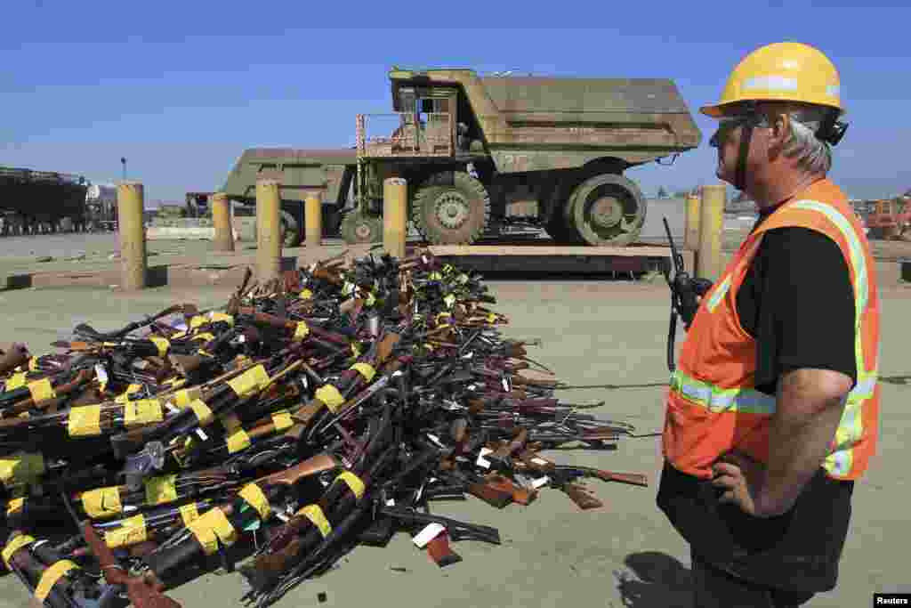 Seorang pekerja berdiri di dekat tumpukan senjata yang akan dihancurkan di sebuah pabrik baja kota Rancho Cucamonga, negara bagian California, AS.