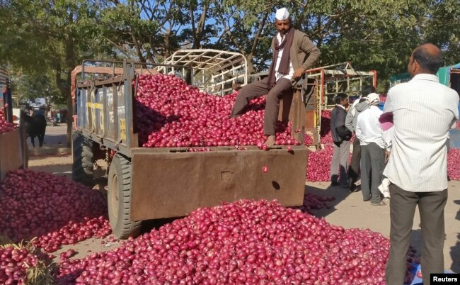 A farmer sits on a tractor trolley after auctioning his onions at Lasalgaon market in Nashik in the western state of Maharashtra, India, Dec. 19, 2018.