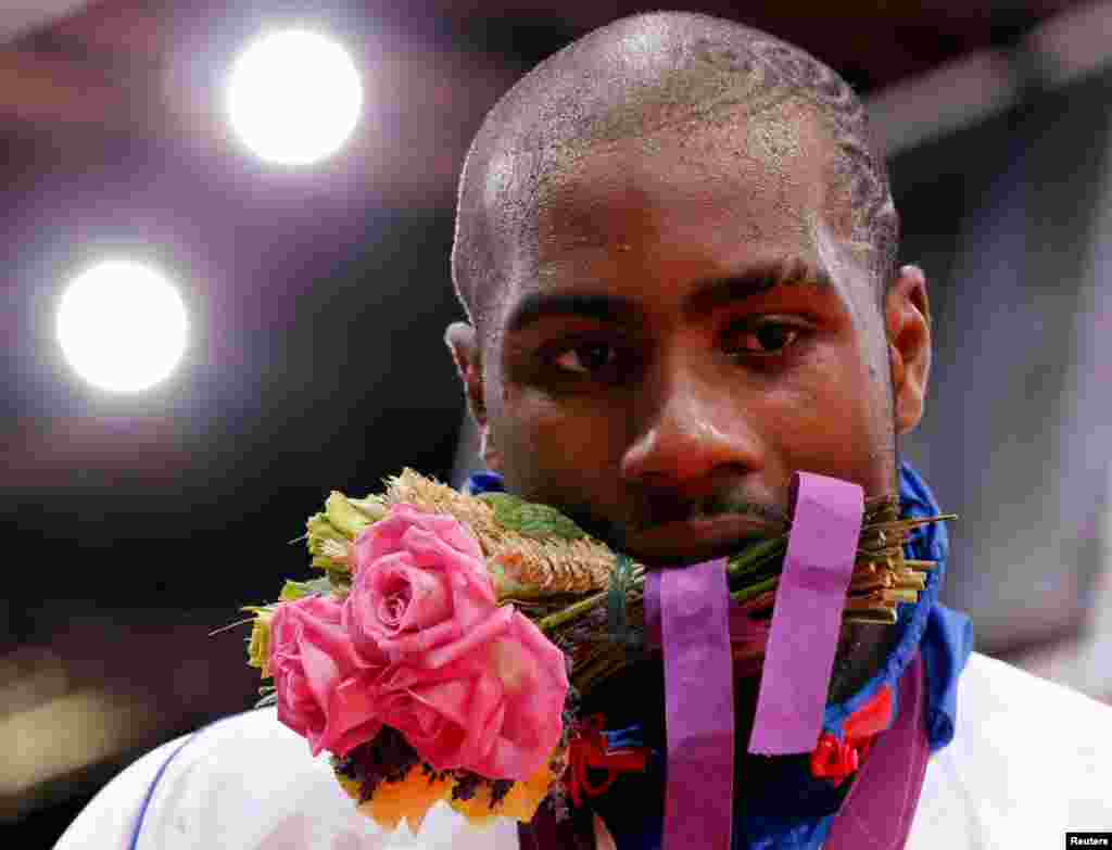 Gold medalist Teddy Riner, of France, holds his bouquet at the victory ceremony for the men&#39;s +100kg judo event.