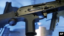 FILE - A little-known device called a "bump stock" is attached to a semi-automatic rifle at the Gun Vault store and shooting range, in South Jordan, Utah, Oct. 4, 2017. The device was used by Las Vegas shooter Stephen Paddock.