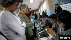 People register to cast their vote at a polling station during a legislative election, in Caracas December 6, 2015. (REUTERS/Carlos Garcia Rawlins)