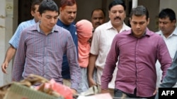 Indian policemen escort the juvenile (C, in pink hood), accused in the December 2012 gang-rape of a student, following his guilty verdict at a court in New Delhi, Aug. 31, 2013. 