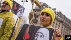 Seorang pengunjuk rasa berpose dengan tali simbolis di lehernya saat demonstran oposisi Iran menggelar aksi unjuk rasa di Paris, Prancis, menentang eksekusi. (Foto: AP)