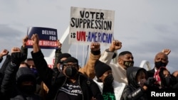 FILE - US civil rights activists hold a Peace Walk on the Frederick Douglass Memorial Bridge to urge Democrats to pass a law protecting voting rights during Martin Luther King Jr. Day in Washington, Jan. 17, 2022.