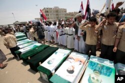 FILE - Yemeni people attend the funeral of victims of a Saudi-led airstrike, in Sa'ada, Yemen, Aug. 13, 2018.