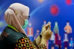 Seorang petugas kesehatan bersiap untuk memberikan vaksin Sinovac di Rumah Sakit Zainoel Abidin di Banda Aceh pada 21 Januari 2021. (Foto: AFP/Chaideer Mahyuddin)