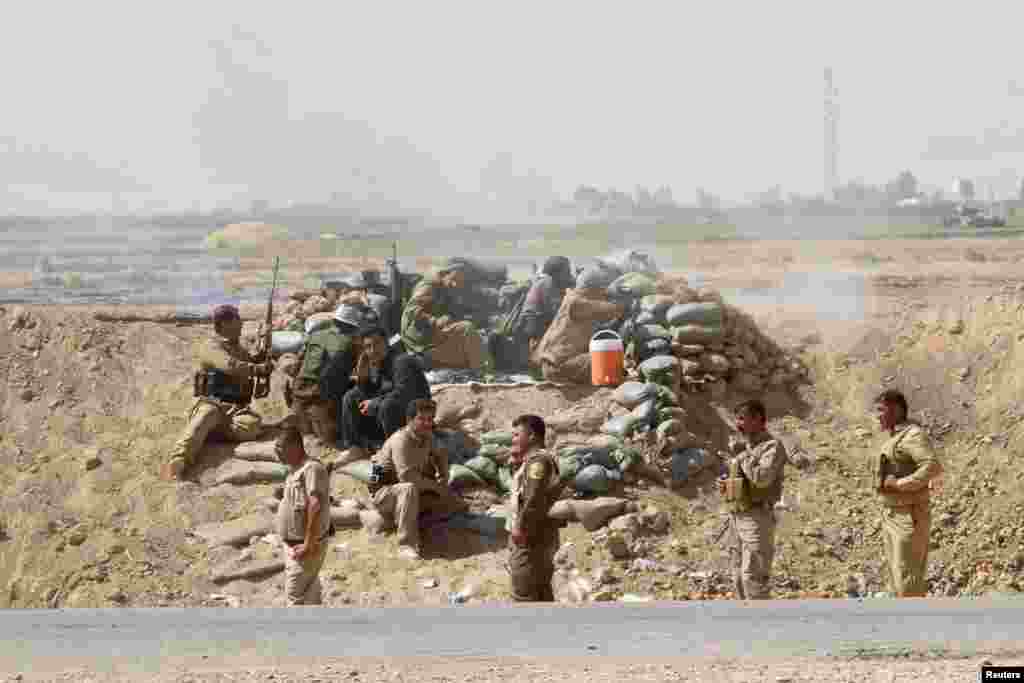 Volunteers with Kurdish peshmerga forces clash with Islamic State militants in the town of Daquq, south of Kirkuk, Sept. 30, 2014. 