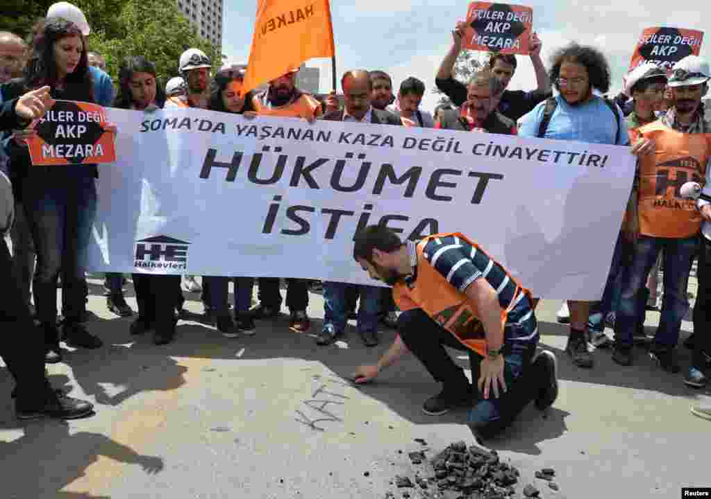 A protester writes "murderer" with piece of coal on the ground as they demonstrate to blame the ruling AK Party (AKP) government on the mining disaster in western Turkey, in Ankara May 14, 2014. Rescuers pulled more dead and injured from a coal mine in we