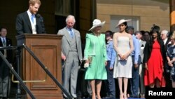 Pangeran Harry and istrinya Meghan Markle di acara pesta kebun di Istana Buckingham bersama Pangeran Charles dan istrinya Camilla yang bergelar Duchess of Cornwall, 22 Mei 2018.