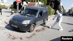 A member of a Tunisian police forensics team works at the site where a suspected Islamist militant was arrested after wounding two policemen in a knife attack near the parliament building in Tunis, Nov. 1, 2017. 