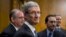 Apple CEO Tim Cook, center, is surrounded by his team during a break from testifying on Capitol Hill in Washington, May 21, 2013. 