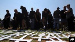 FILE - People place crosses, symbolically representing farmers killed in the country, at a ceremony at the Vorrtrekker Monument in Pretoria, South Africa, Oct. 30, 2017. U.S. President Donald Trump has tweeted that he has asked the Secretary of State Mike Pompeo to "closely study the South African land and farm seizures and expropriations and the large scale killing of farmers." South Africa has responded that Trump is "misinformed."