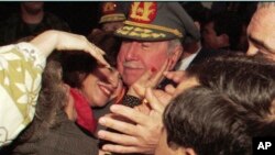 En esta imagen de archivo, el difunto dictador chileno, entonces comandante del ejército, general Augusto Pinochet, recibe el abrazo de una seguidora con motivo del 22º aniversario de su nombramiento como jefe de las fuerzas armadas, en Santiago, Chile, el 23 de agosto de 1995. 