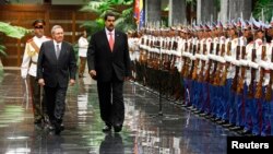 El presidente venezolano Nicolás Maduro pasa revista a la guardia de honor junto a su colega Raúl Castro, en La Habana.