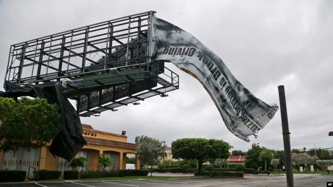 A billboard canvas flaps in the wind after Hurricane Matthew passed off shore, Oct. 7, 2016, in North Palm Beach, Fla. 
