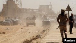 Members of the Libyan National Army make their way to the gates of pro-government Rafalla al-Sihati brigade after demonstrators attacked the brigade's base in Benghazi city, September 22, 2012.