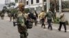 (FILE) A member of the M23 armed group monitors as men believed to be Romanian military contractors line up near the border post crossing into Rwanda, in Goma on January 29, 2025.