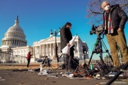 Miembros de la prensa inspeccionan equipos que fueron dañados fuera del Capitolio un día después que los partidarios del presidente Donald Trump irrumpieron y ocuparon el capitolio el 6 de enero.