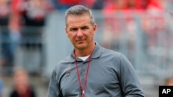 FILE - Ohio State coach Urban Meyer watches the NCAA college football team's spring game in Columbus, Ohio, April 14, 2018. Ohio State has placed Meyer on paid administrative leave while it investigates claims that his wife knew about allegations of abuse against an assistant coach years before he was fired last week.